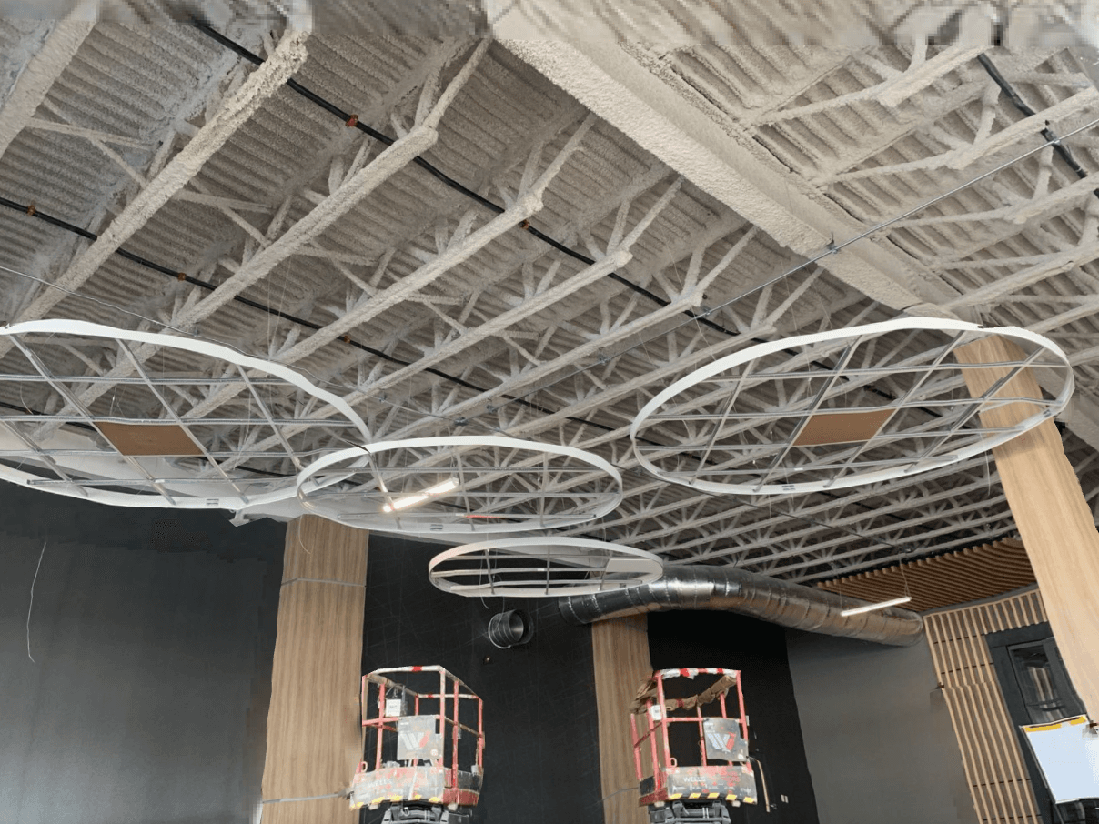 Circular ceiling features framed below an open-web steel roof structure