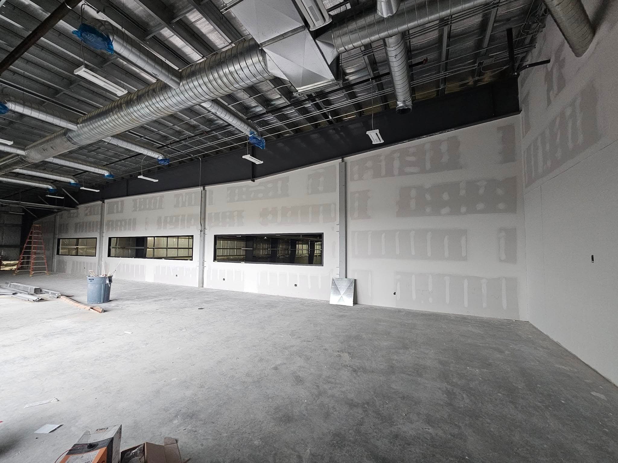 Drywall installed along a commercial interior with clerestory windows