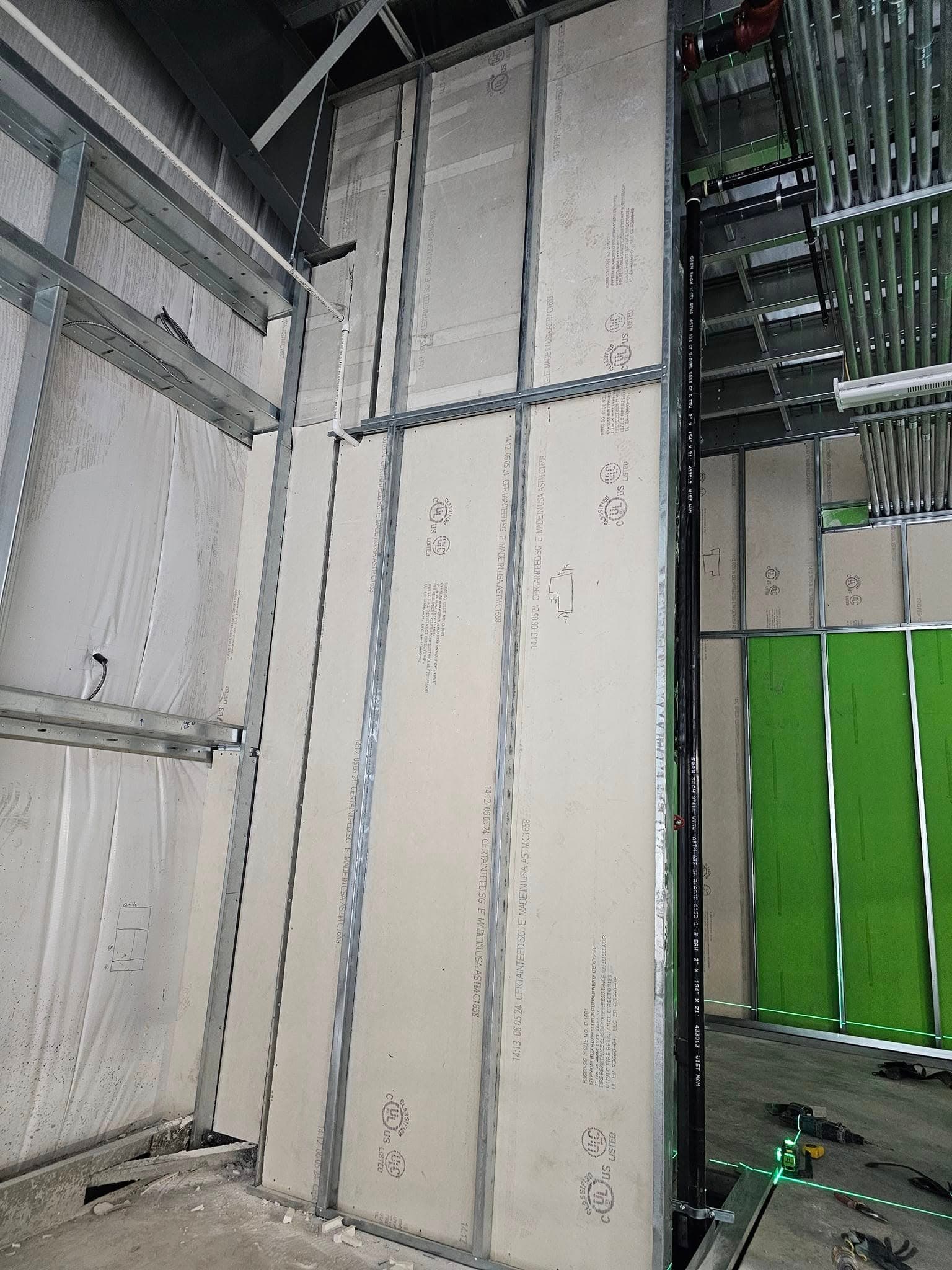 Steel stud partition framing with boarding in progress