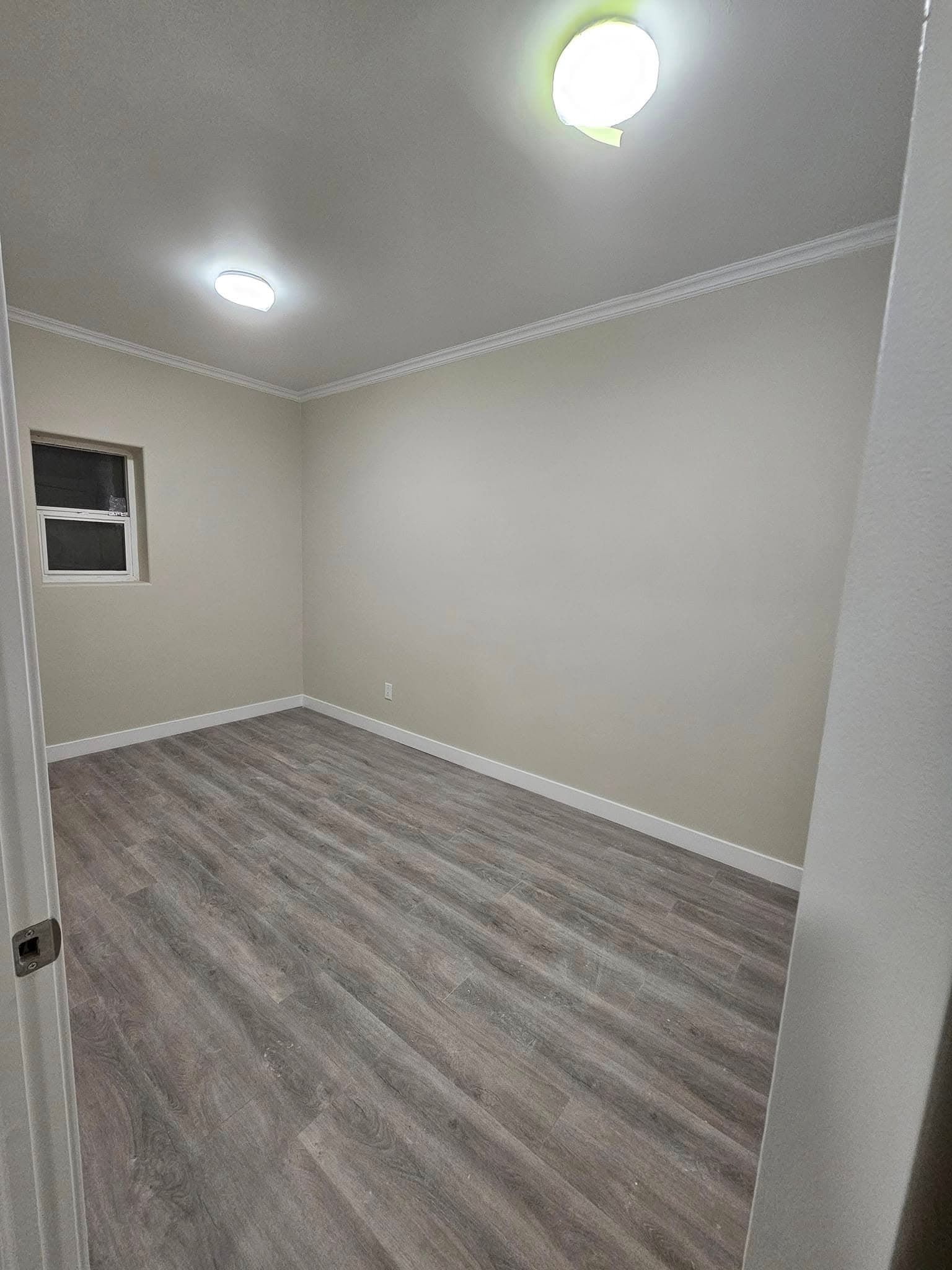 Finished room with fresh paint, trim and vinyl plank flooring