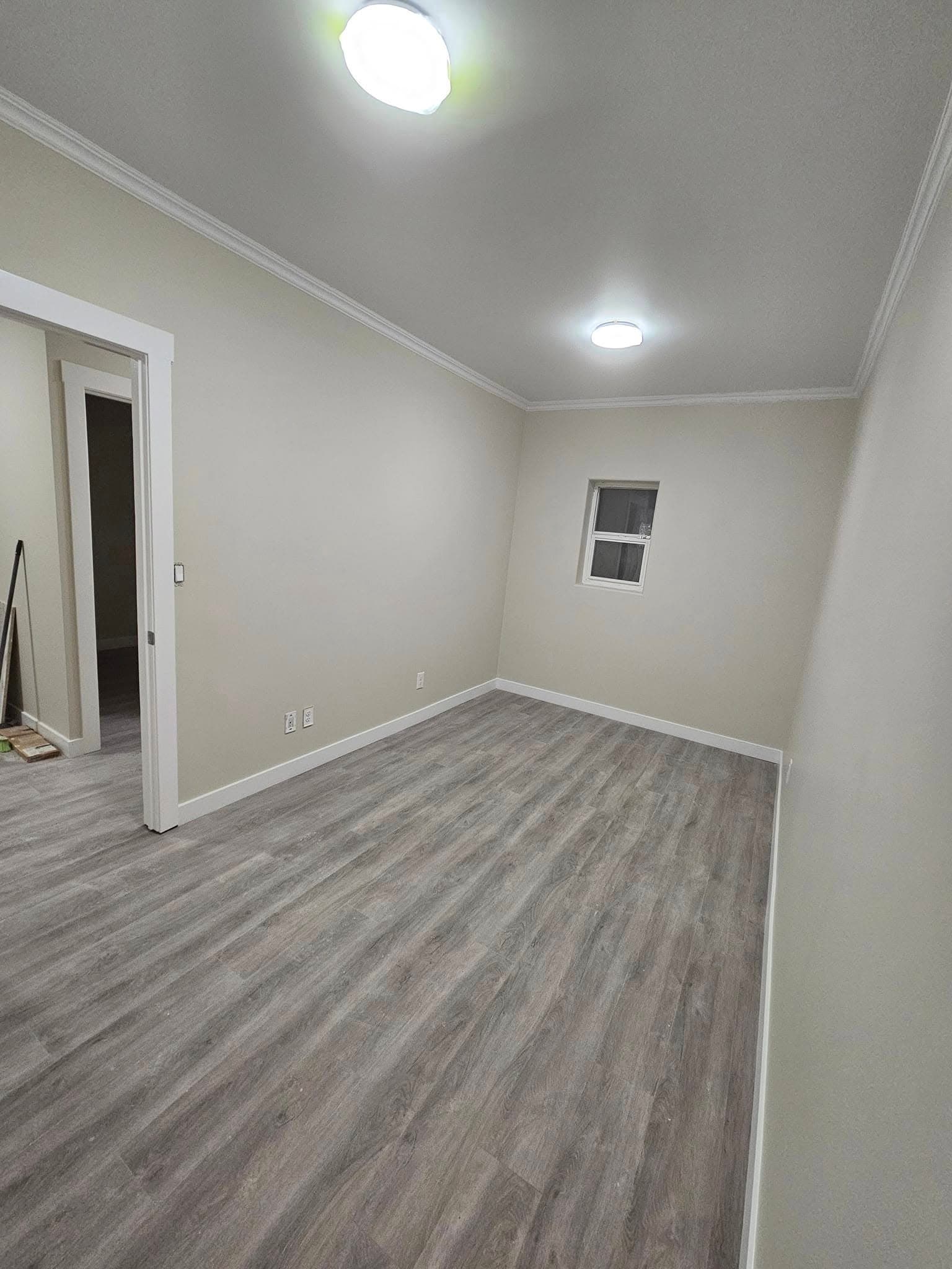 Finished bedroom with new flooring, trim and lighting