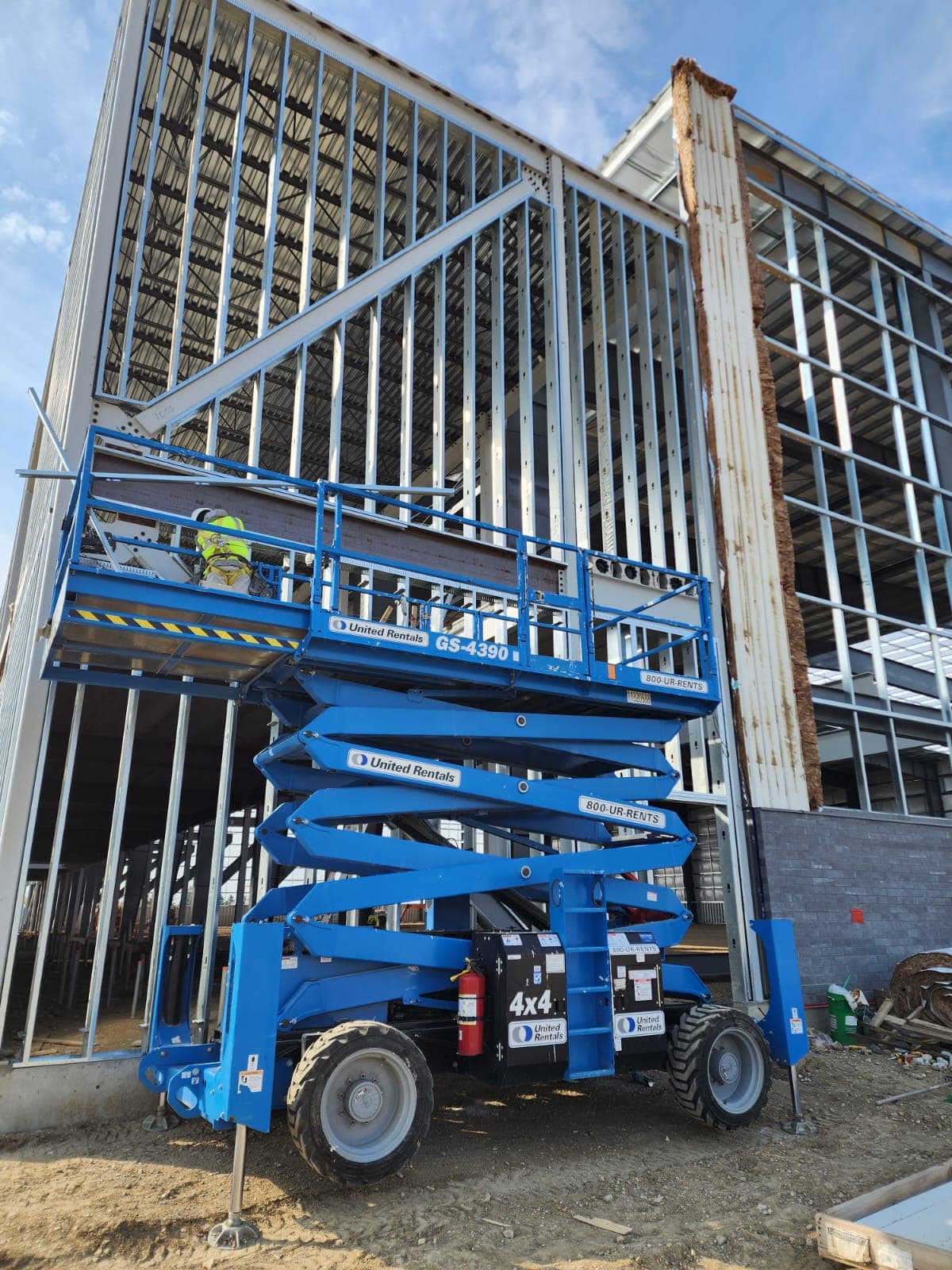 Crew on a scissor lift framing an exterior steel stud wall