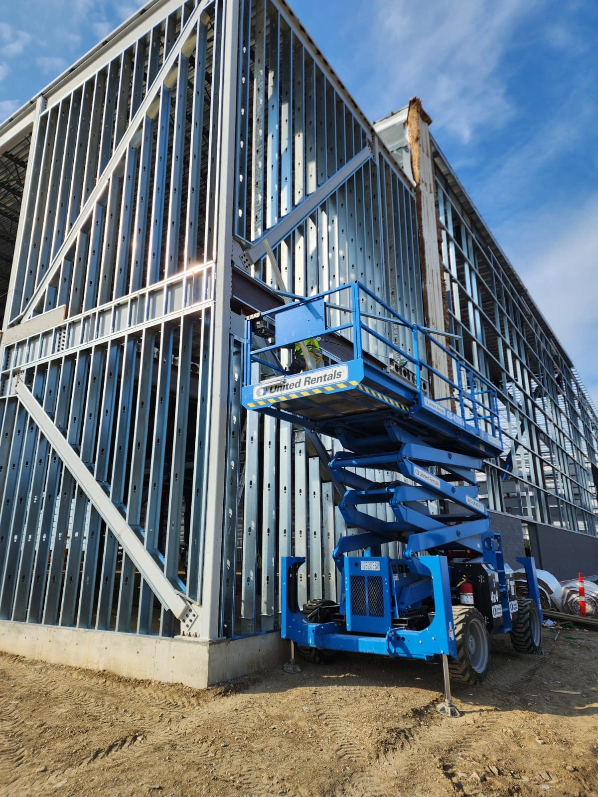 Multi-storey exterior steel stud wall framing with a scissor lift