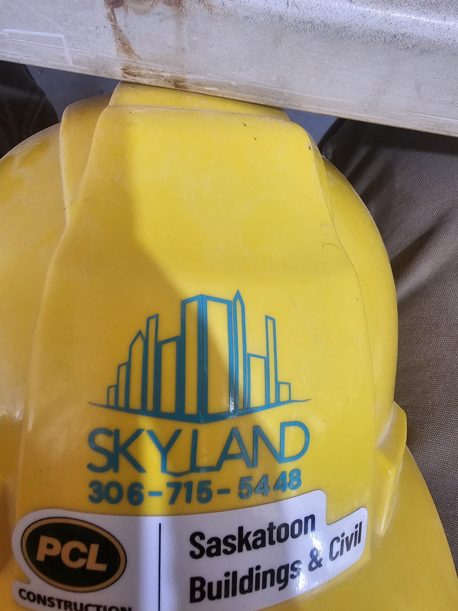 Skyland Construction branded hard hat on a job site